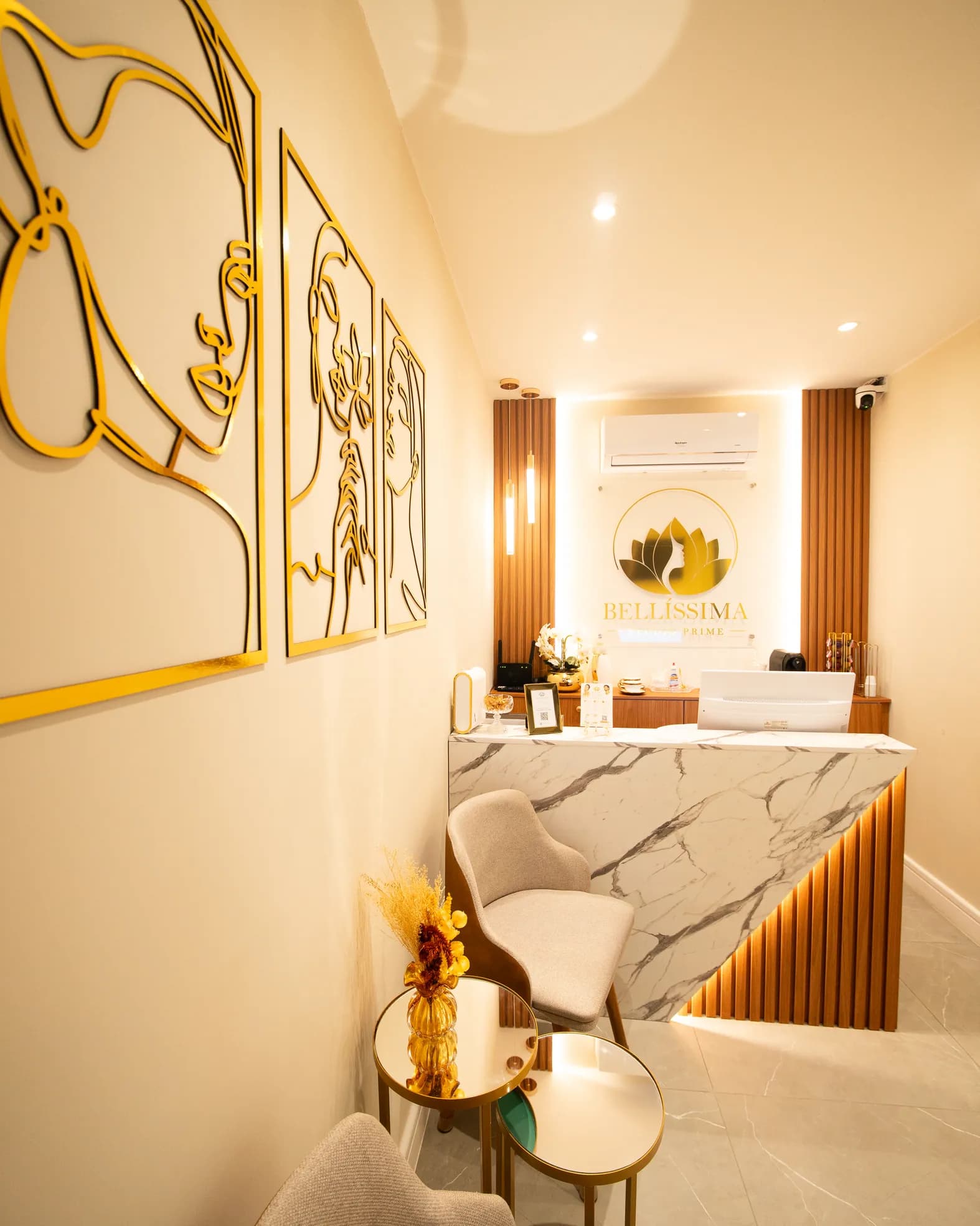 Recepção do spa com balcão de mármore e painel ripado de madeira